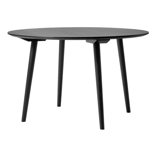 Round black table with sleek minimalist design and tapered legs, perfect for contemporary spaces.