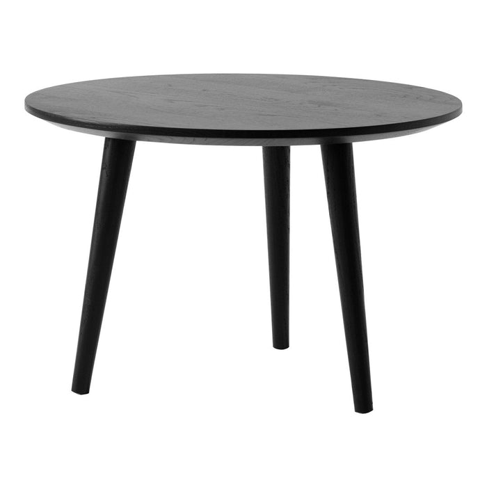 Round black table with a smooth surface and sleek tapered legs, showcasing a minimalist design.
