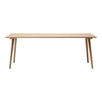 Natural wood finish dining table with a minimalist design and light color. Simple, clean lines enhance any space.
