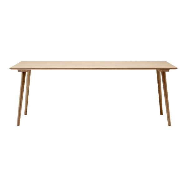 Natural wood finish dining table with a minimalist design and light color. Simple, clean lines enhance any space.