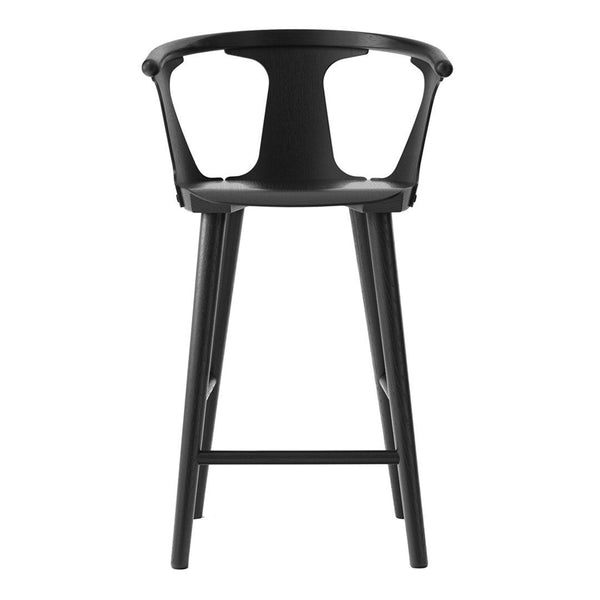 Black bar stool with a minimalist design and smooth finish, featuring unique curved patterns. Perfect for modern decor.