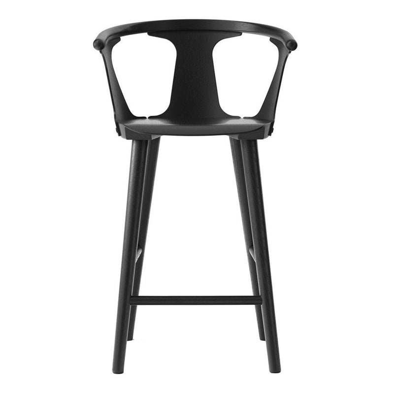 Black bar stool with a minimalist design and smooth finish, featuring unique curved patterns. Perfect for modern decor.