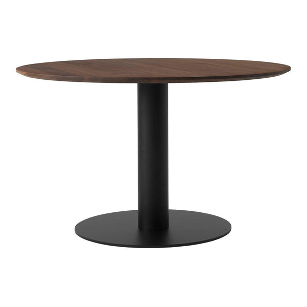 Round wooden dining table with a walnut finish and a sleek black metal base. Modern minimalist design.