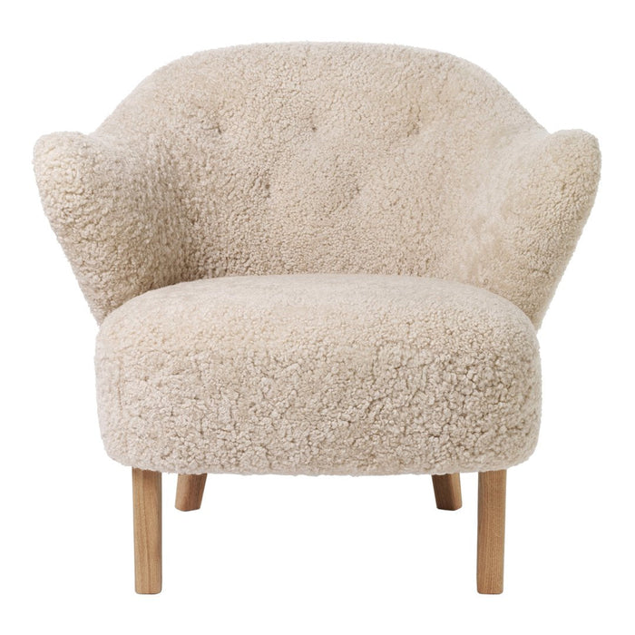 Cream textured armchair with plush upholstery and wooden legs, featuring a cozy, rounded design. Perfect for modern decor.