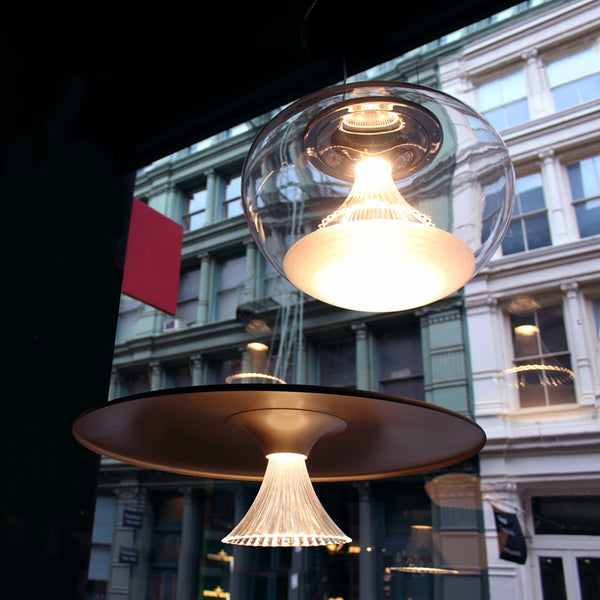 Modern pendant lights featuring clear glass and sleek metal finishes in a warm, inviting glow.