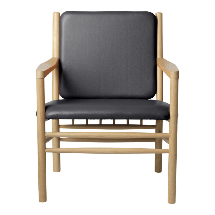 Black leather armchair with natural wood frame, featuring a sleek, minimalist design and no intricate patterns.