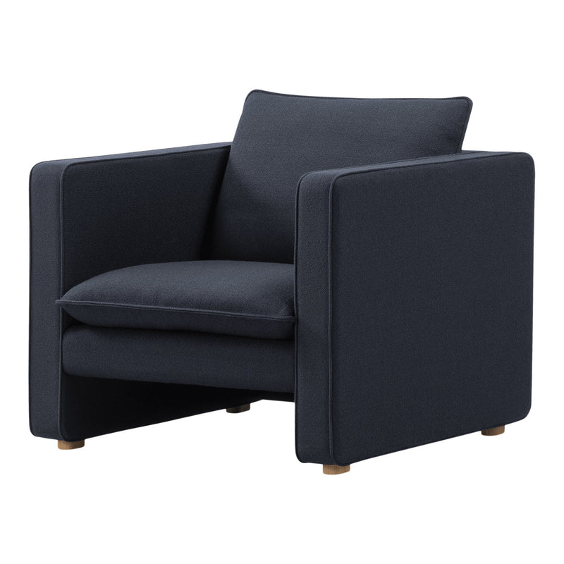 Dark blue upholstered armchair with a sleek design and minimalist wood legs, featuring a textured fabric pattern.