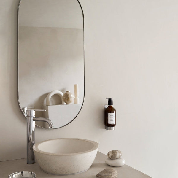 Neutral beige bathroom basin with soft curves, featuring a sleek silver faucet and minimalist decor.