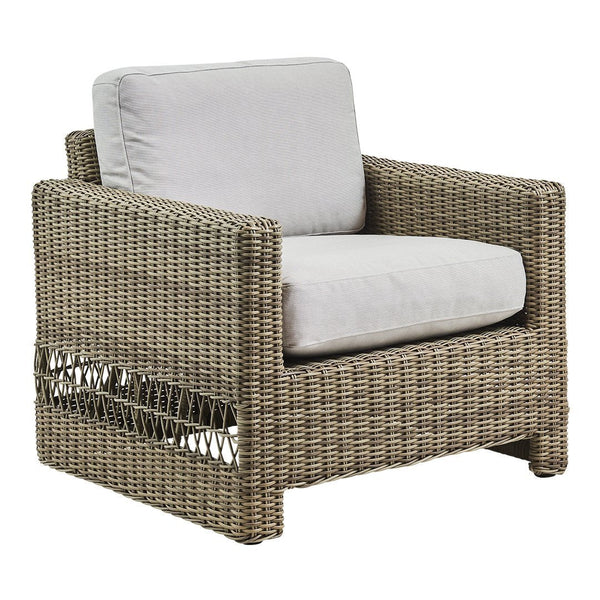 Natural brown woven rattan armchair with light gray cushions, featuring a modern, textured design.