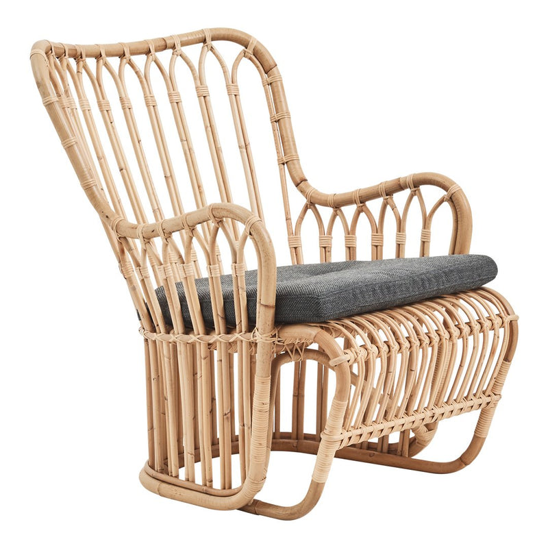 Natural woven rattan chair with a light tan finish and a dark gray cushion, featuring an airy, open-pattern design.
