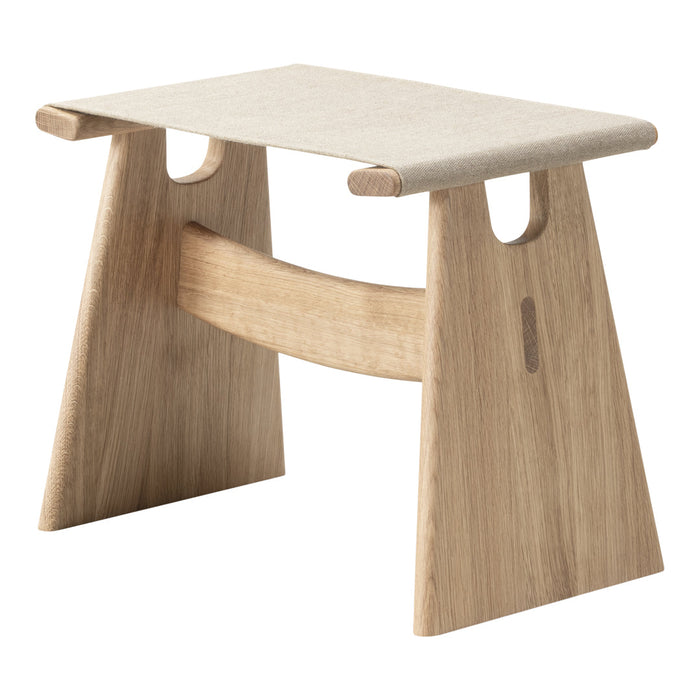 Light wood stool with beige fabric top, featuring a minimalist design and natural textures. Ideal for modern decor.