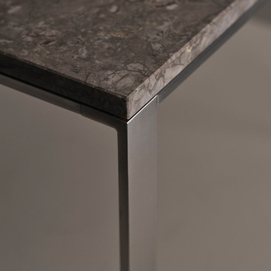 Gray marble tabletop with subtle veining and sleek metallic edges, perfect for modern decor.