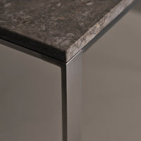 Gray marble tabletop with subtle veining and sleek metallic edges, perfect for modern decor.