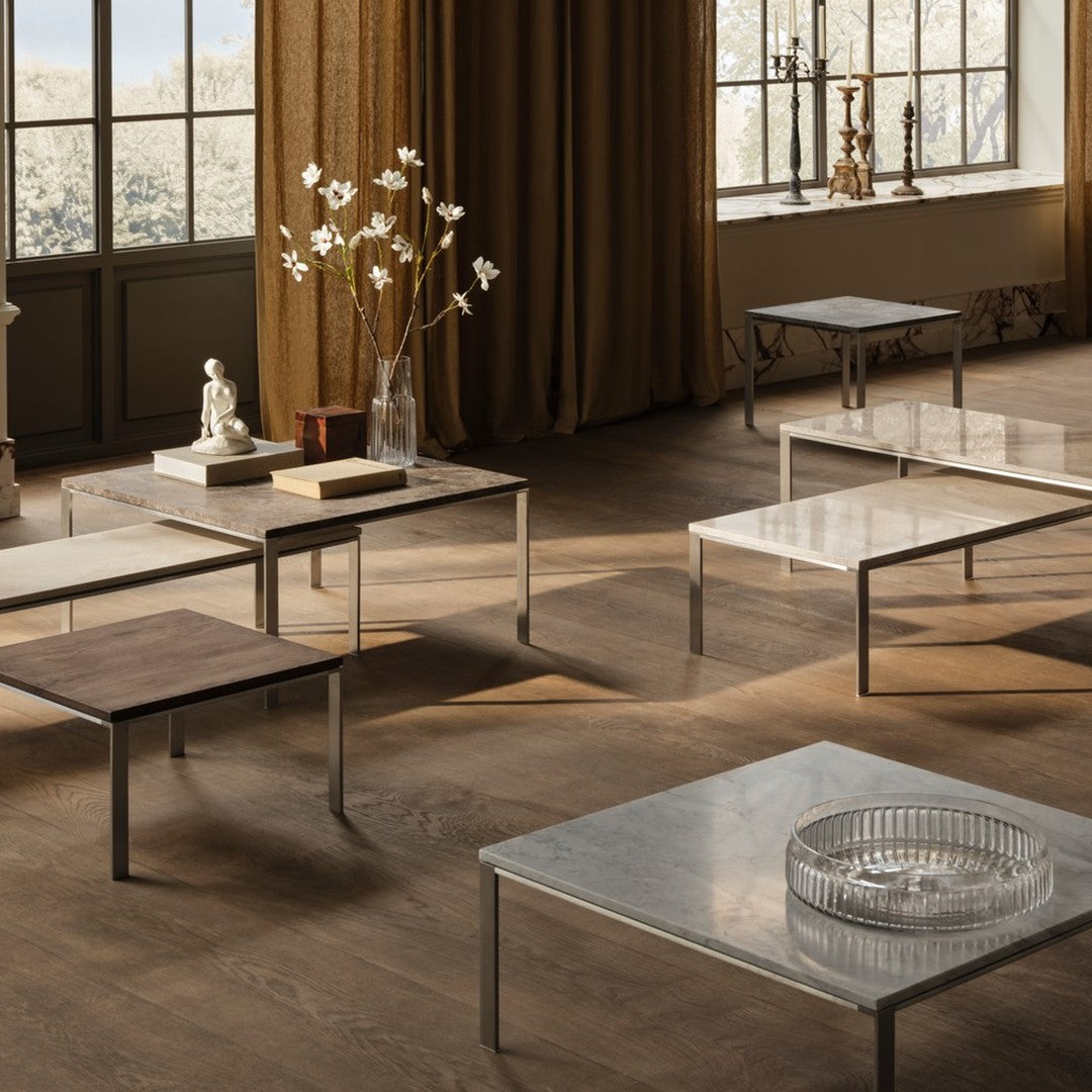 Modern coffee tables in various finishes: light marble, dark wood, and sleek metal with minimalist designs.