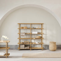 Light wood shelving unit in a soft neutral-toned room, featuring simple, contemporary design with minimalist décor.