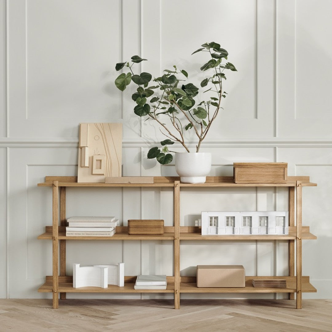 Natural wood finish shelving with light and neutral accents, featuring greenery and clean lines for a modern, serene look.