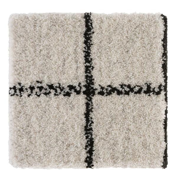 Cream shag rug with a bold black grid pattern, adding texture and modern style to any space.