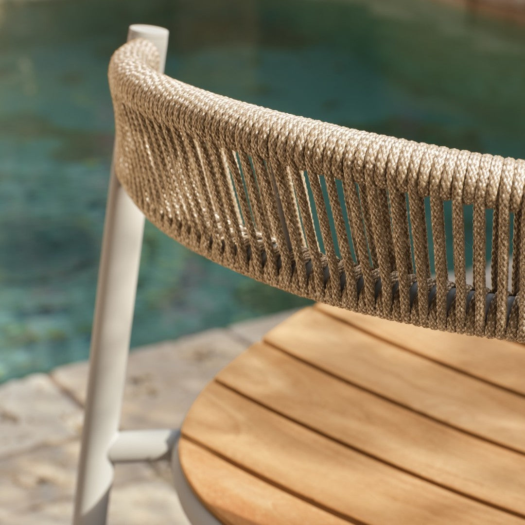 Cream-colored rope seating with a natural wood finish, perfect for outdoor relaxation. Modern design against a pool backdrop.