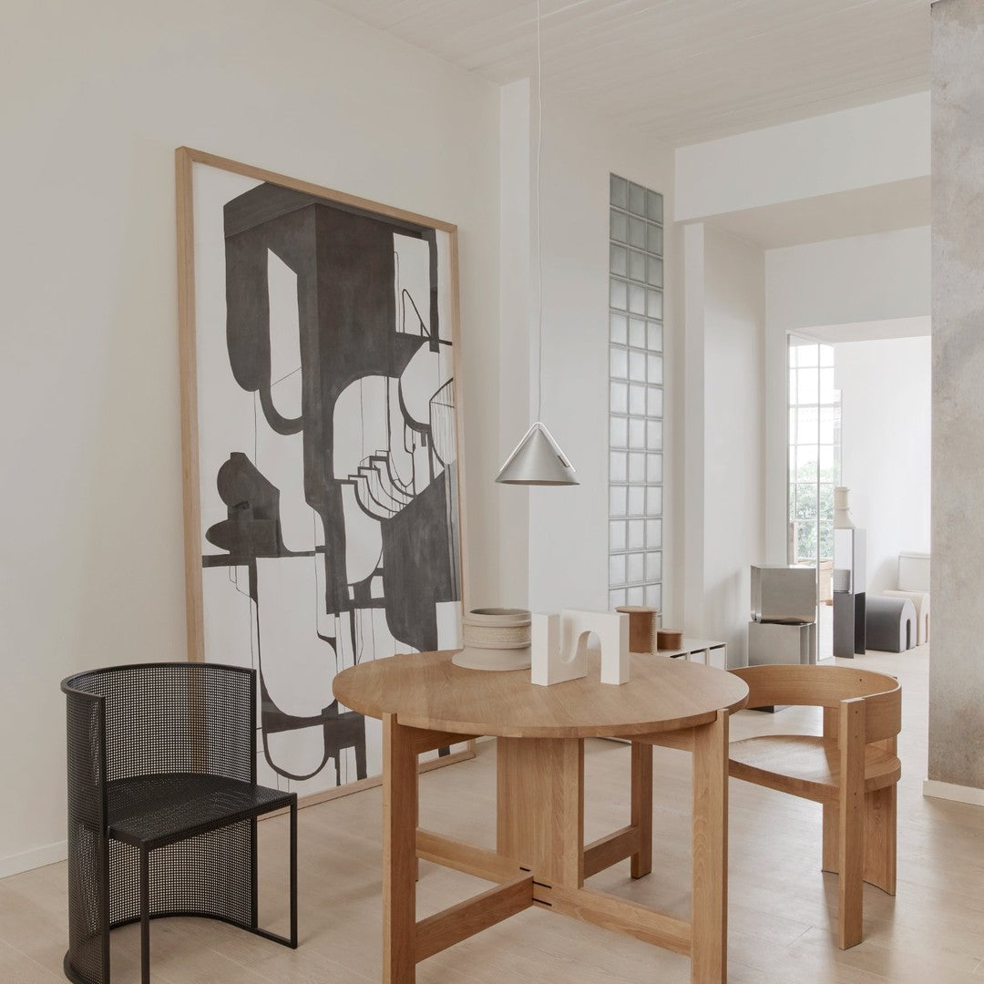Minimalist black and white geometric art on a light-colored wall, paired with natural wood furniture.