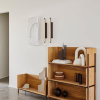 "Modern wooden shelf with natural wood tones, sleek black and white decor, and geometric patterns."