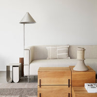 Modern living room featuring beige sofa, textured natural wood accents, and soft gray tones with simple geometric patterns.