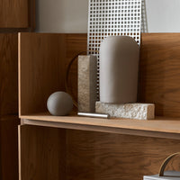 Neutral tones and textured patterns in decorative vases and sculptural objects on a wooden shelf.