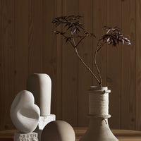 Neutral-toned vases and sculptural decor against a warm wooden backdrop, featuring soft curves and organic shapes.