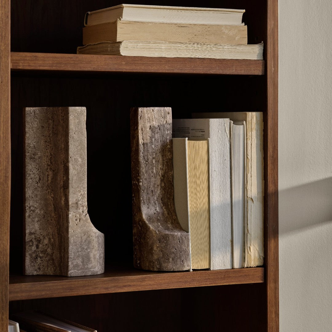 Natural wood bookends with earthy brown tones and textured finishes, displayed with neutral-colored books on a wooden shelf.