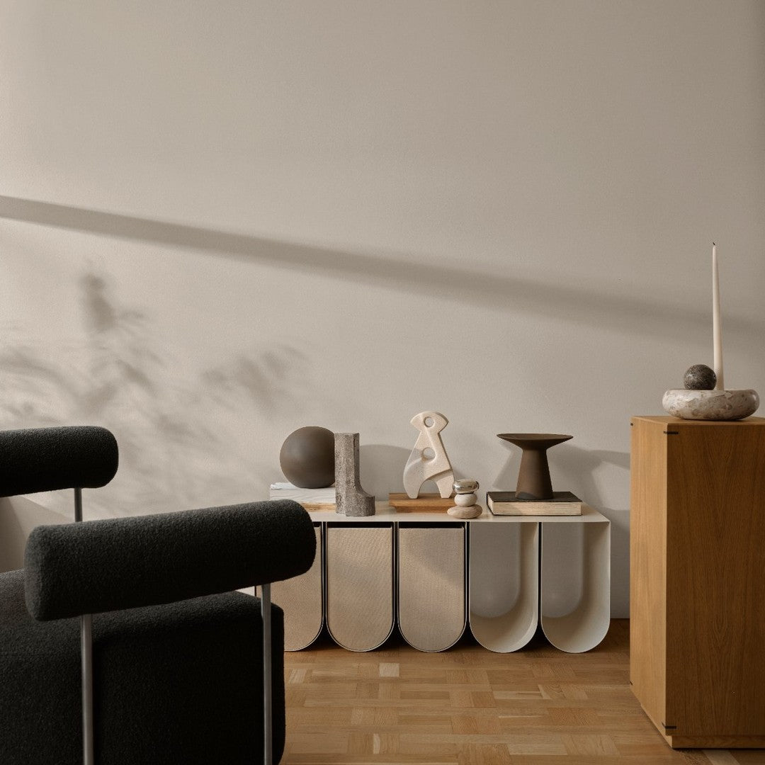 Curved white shelves display neutral decor against a soft gray wall, complemented by earthy wooden tones.