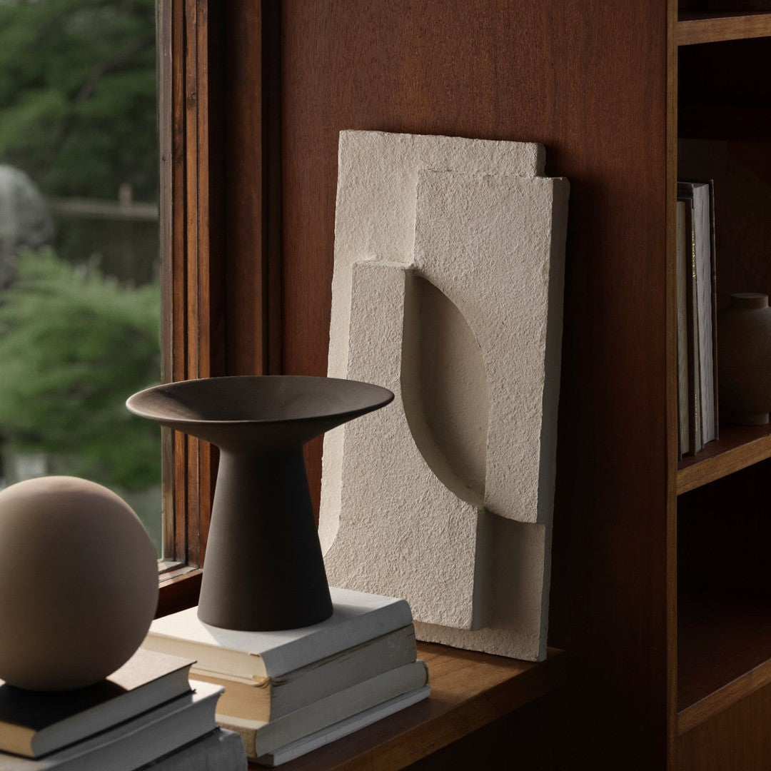 Neutral-toned decorative pieces with textured patterns; minimalist design featuring cream and dark brown hues.