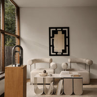 Modern living room featuring neutral tones, organic shapes, and a geometric black-and-white art piece.