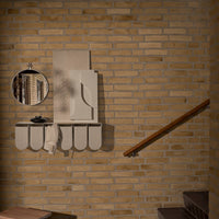 Cream and beige wall shelf with curved edges, reflecting a minimalist design against a warm, textured brick backdrop.