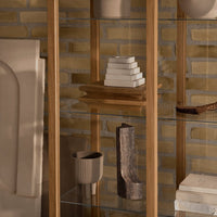 Glass and wooden display shelf featuring neutral tones with textured patterns and warm earthy hues.