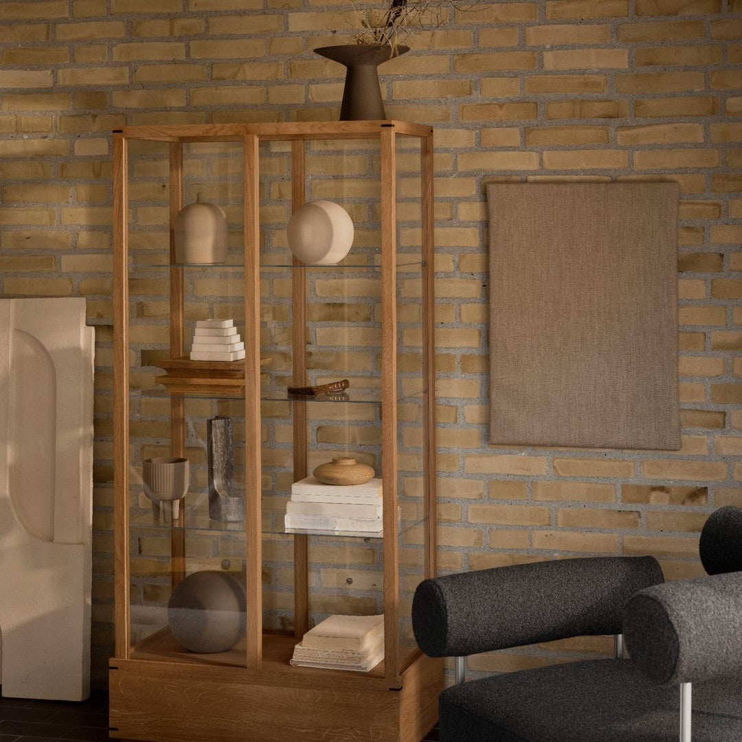 "Wooden display cabinet with neutral tones, soft textures, and minimalist design, paired with a muted wall and decor."