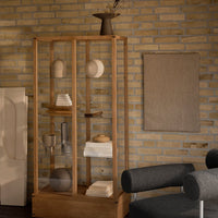 "Wooden display cabinet with neutral tones, soft textures, and minimalist design, paired with a muted wall and decor."