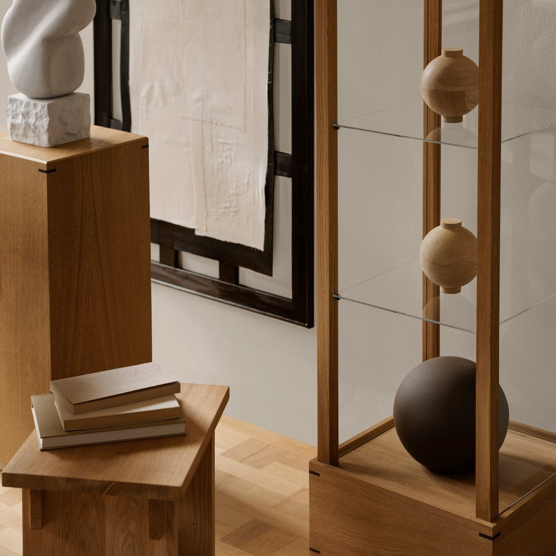 Wooden furniture with natural finishes, geometric shapes, and soft earth tones create a modern, minimalist aesthetic.