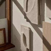 Textured neutral wall art in soft beige and creamy tones, featuring geometric shapes and a modern aesthetic.