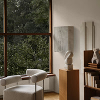Elegant white sculptural decor against a neutral-toned wall, with soft textures and natural green outdoor views.