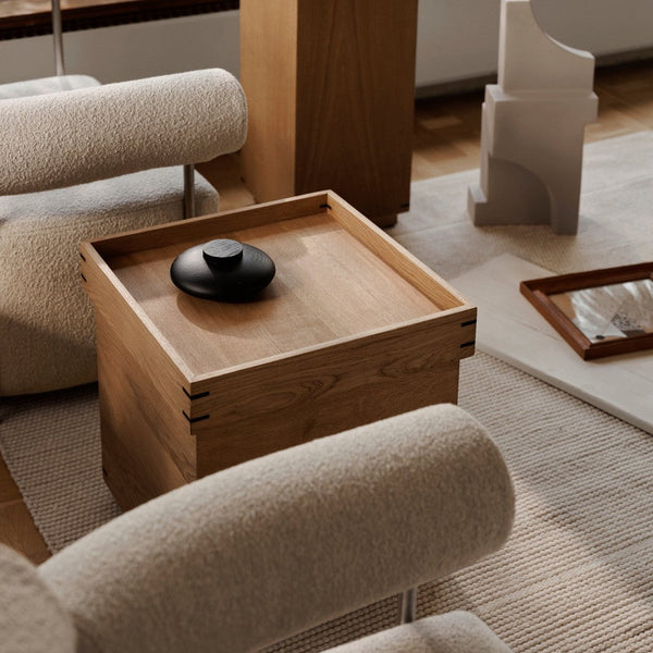 "Natural wood grain with sleek black accents; soft beige and woven textures create a warm, inviting atmosphere."