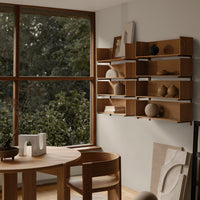 "Natural wood shelving with soft earthy tones and minimalist design, complemented by neutral decor and greenery."