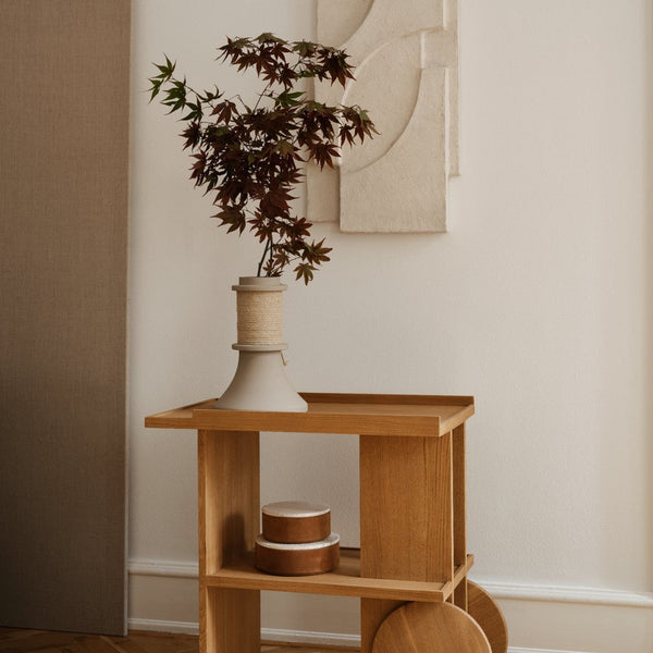 Wooden cart with a natural finish, featuring warm tones and minimalist design, adorned with earthy plants and textures.