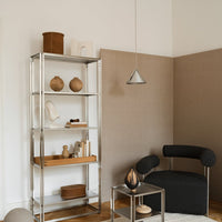 Modern shelving unit with metallic silver frame and wooden accents, set against beige and cream-toned walls.