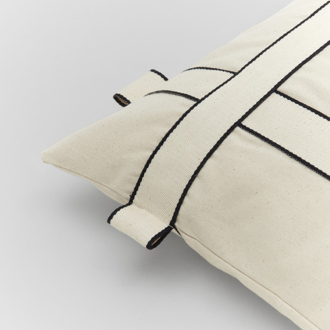 Cream pillow with black geometric stripes and contrasting detailing, perfect for modern home decor.