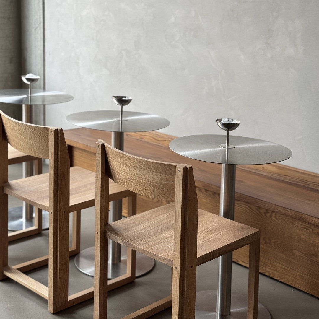 "Modern wooden chairs with sleek metal tables, featuring neutral tones and minimalist design."