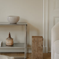Neutral gray shelf with light wood accents, a soft beige bowl, and rustic wooden elements, creating a calming decor aesthetic.