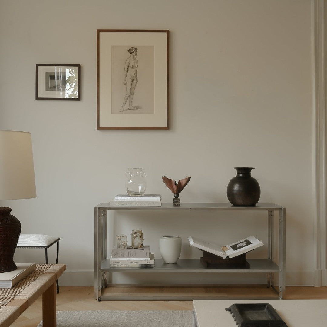 Modern minimalist living room with neutral tones, black accents, and subtle textures, featuring a stylish console table.