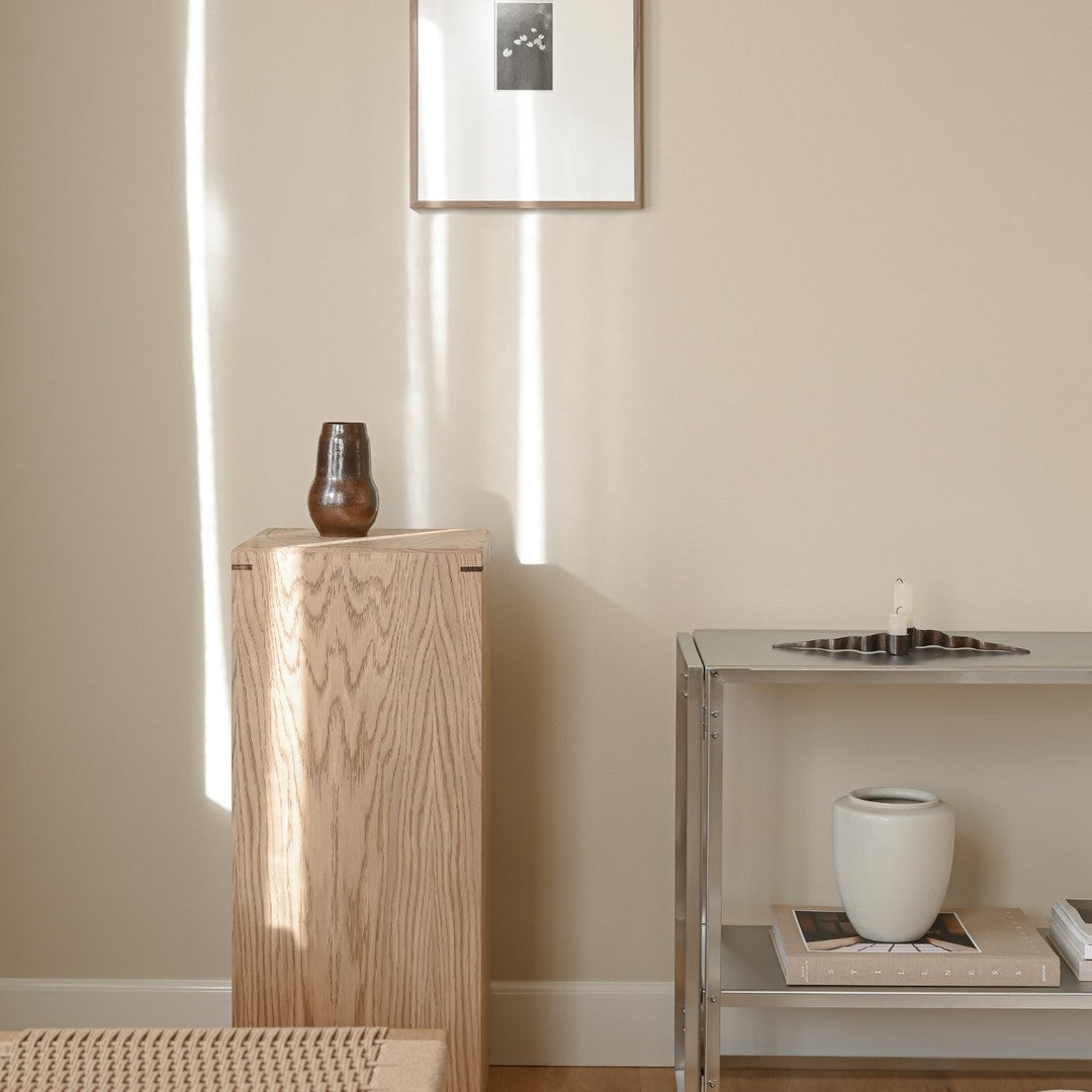 Natural wood tones and soft beige walls create a warm, minimalist aesthetic with subtle shadows and light patterns.