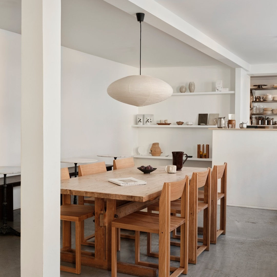 Light wood dining table with natural grain, paired with minimalist beige chairs. Soft, neutral tones create a serene atmosphere.