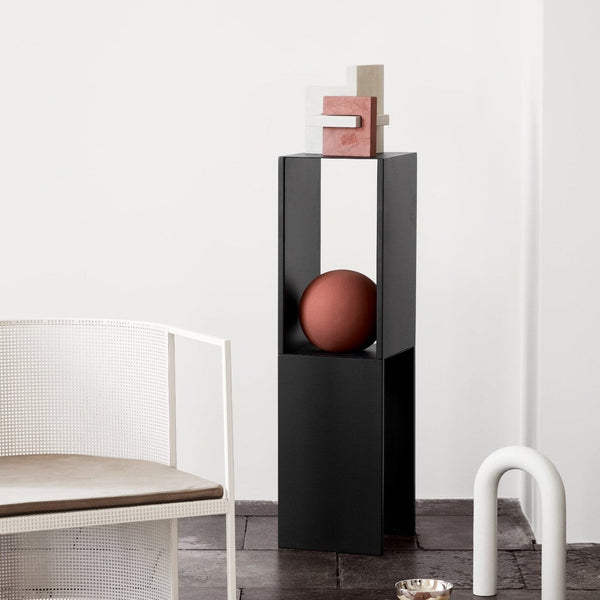 "Modern black pedestal with geometric accents; featuring earthy tones and a minimalist design."