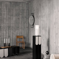 Modern interior featuring gray wood walls, black and white furniture with minimalist geometric patterns.